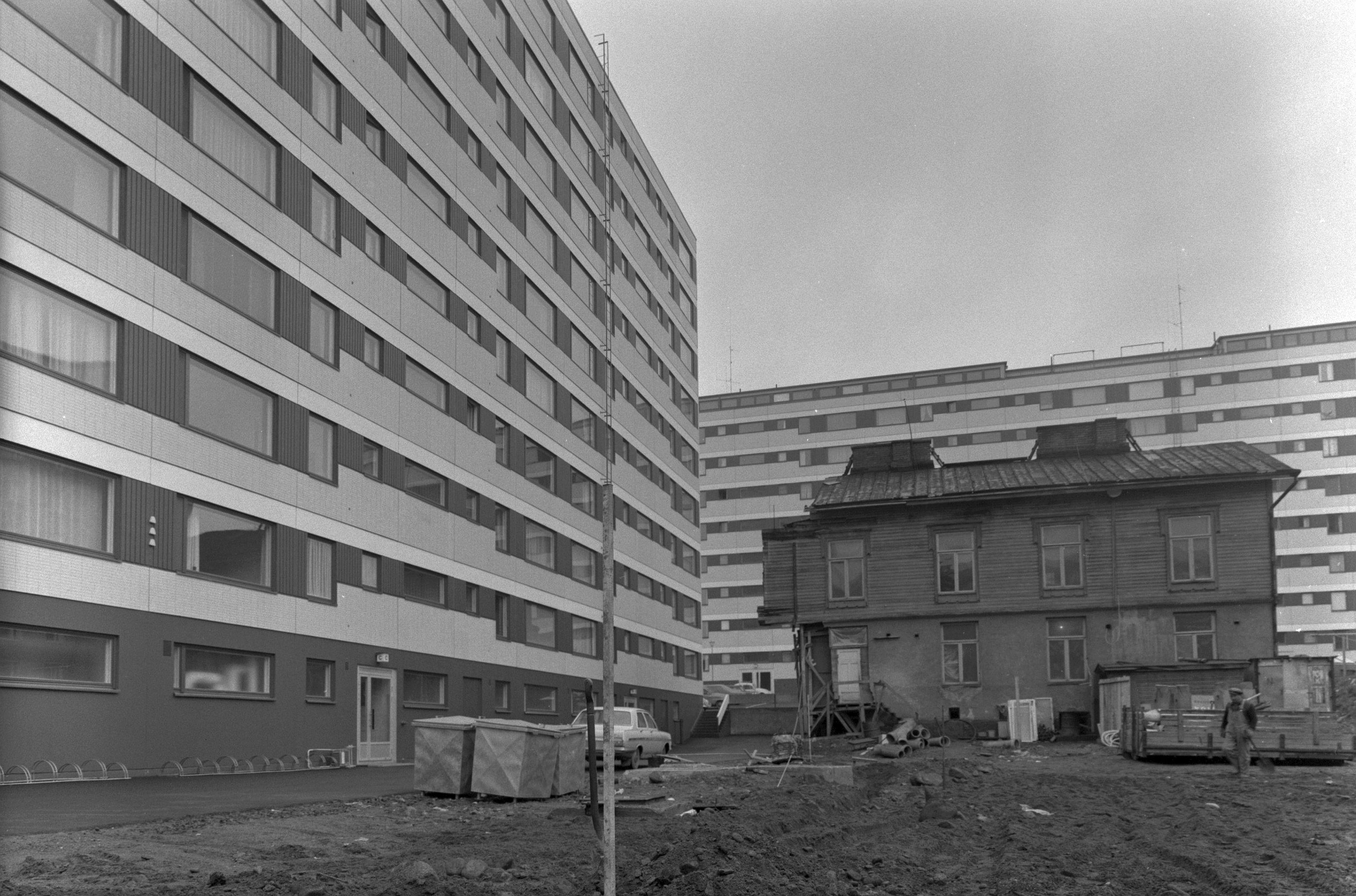 Uusia 10-kerroksisia kerrostaloja vanhan puutalon ympärillä.