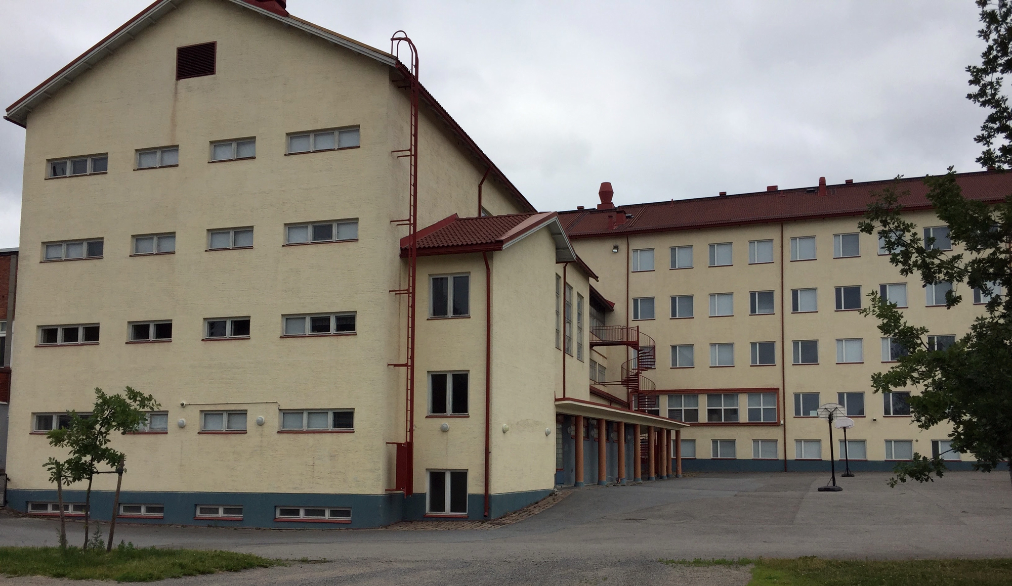Ulkokuva vaaleasta kivirakennuksesta, jossa on punainen katto.