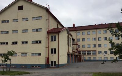 Ulkokuva vaaleasta kivirakennuksesta, jossa on punainen katto.
