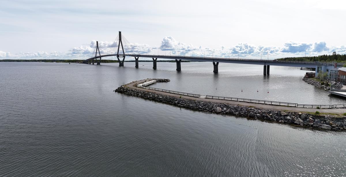 Järvimaisema, jota halkoo silta. Etualalla on aallonmurtaja.